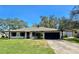 Charming one-story home with a lush green lawn, mature trees, long driveway, and a single-car garage at 527 Leland Dr, Deltona, FL 32725