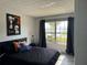 Comfortable bedroom with stylish decor, large windows, and a glimpse of the outside view at 5427 Hansel Ave # 9, Orlando, FL 32809