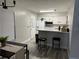 Well-lit kitchen features white cabinets, modern appliances, and a breakfast bar with seating at 5427 Hansel Ave # 9, Orlando, FL 32809