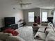 Spacious living room with comfortable sectional sofa, television, ceiling fan, and abundant natural light at 5427 Hansel Ave # 9, Orlando, FL 32809