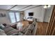Comfortable living room with a plush sectional sofa, hardwood floors, and bright natural light through sliding glass doors at 6222 Dovecrest Trl, Lakeland, FL 33810