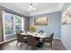 Elegant dining room featuring a modern table, seating for six, and a large window with natural light at 640 Brookfield Pl, Apopka, FL 32712