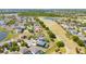 Aerial view showcases a home near a golf course with mature trees, and pond, offering recreational lifestyle at 654 Chadbury Way, Kissimmee, FL 34744