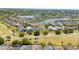 A beautiful aerial shot displays a community with a pond, golf course, and well-maintained houses at 654 Chadbury Way, Kissimmee, FL 34744