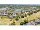 Aerial view of a residential area with a golf course, pond, and well-maintained homes at 654 Chadbury Way, Kissimmee, FL 34744