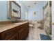 Bathroom with light blue walls, granite countertops, and a tiled shower at 654 Chadbury Way, Kissimmee, FL 34744
