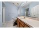 Bathroom with large mirror, vanity with cream countertop, and tiled floors, plus glass-doored shower at 654 Chadbury Way, Kissimmee, FL 34744