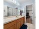 Bathroom with a wood vanity and a large mirror with bright lighting above at 654 Chadbury Way, Kissimmee, FL 34744