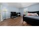 Bright bedroom with hardwood floors features a desk and chair and comfortable bed with a variety of cute pillows at 654 Chadbury Way, Kissimmee, FL 34744
