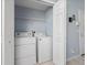 Compact laundry closet with a washer and dryer with a shelf for supplies at 654 Chadbury Way, Kissimmee, FL 34744