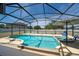 Screened-in pool with attached spa, lounge chairs, and patio umbrella at 654 Chadbury Way, Kissimmee, FL 34744