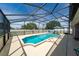 A screened pool area features a pool, spa, patio and blue skies at 654 Chadbury Way, Kissimmee, FL 34744
