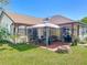Spacious backyard with a covered patio, fire pit, and lush green lawn at 6559 Grosvenor Ln, Orlando, FL 32835
