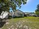 Landscaped backyard with lush green lawn, storage shed, bench seating, and outdoor living area at 6559 Grosvenor Ln, Orlando, FL 32835