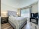 Bedroom with wood floors features a large window and television at 6559 Grosvenor Ln, Orlando, FL 32835