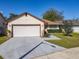 Home exterior with attached two-car garage, well-kept lawn, and landscaped garden at 6559 Grosvenor Ln, Orlando, FL 32835