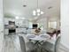 Open-concept kitchen with stainless steel appliances and a dining area, leading to a living room at 6559 Grosvenor Ln, Orlando, FL 32835