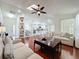 Open-concept living room with hardwood floors, a ceiling fan, and seamless flow to the kitchen at 6559 Grosvenor Ln, Orlando, FL 32835