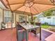 Backyard patio with a dining set under a canopy, plus a fire pit for cozy evenings at 6559 Grosvenor Ln, Orlando, FL 32835