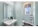Cozy powder room featuring a pedestal sink, window, and charming decor at 6665 Bridgman St, Orlando, FL 32827