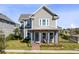 Inviting two-story home boasts a charming front porch, complemented by lush green landscaping and a well-manicured lawn at 6665 Bridgman St, Orlando, FL 32827