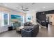 Stylish living room with a sleek ceiling fan, modern furniture, and abundant natural light from large windows at 6665 Bridgman St, Orlando, FL 32827