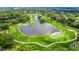 Scenic aerial view of a lush golf course surrounded by a lake and mature trees at 7455 Sparkling Lake Rd, Orlando, FL 32819
