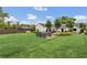 Expansive backyard with lush lawn, brick patio featuring a hot tub and outdoor dining set at 7455 Sparkling Lake Rd, Orlando, FL 32819