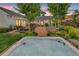 Enjoy the backyard's hot tub with brick-paved patio, lush landscaping, and outdoor seating at dusk at 7455 Sparkling Lake Rd, Orlando, FL 32819