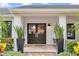 Inviting front entrance featuring double doors flanked by tall snake plants and a cozy seating area at 7455 Sparkling Lake Rd, Orlando, FL 32819