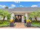 Elegant front entrance with double doors, lush landscaping, and stylish planters creating a welcoming appeal at 7455 Sparkling Lake Rd, Orlando, FL 32819