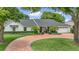 Beautiful white home featuring a circular driveway, palm trees, and manicured landscaping at 7455 Sparkling Lake Rd, Orlando, FL 32819