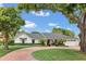 Charming home featuring mature trees, manicured landscaping, circular driveway and elegant architecture at 7455 Sparkling Lake Rd, Orlando, FL 32819