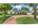 Charming single-story home featuring a brick driveway, manicured lawn, and lush landscaping at 7455 Sparkling Lake Rd, Orlando, FL 32819