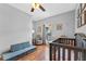 Bright Bedroom features wood floors, a dark wood crib, chair, and comfortable sofa at 820 Timber Isle Dr, Orlando, FL 32828