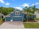 Charming two-story home featuring a three-car garage, lush landscaping, and a brick driveway at 820 Timber Isle Dr, Orlando, FL 32828