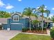 Charming blue two-story home with a three car garage and well-manicured landscaping at 820 Timber Isle Dr, Orlando, FL 32828