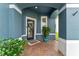 Inviting front porch with brick flooring, colorful plants, and a wreath-adorned door at 820 Timber Isle Dr, Orlando, FL 32828