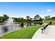 Scenic pond view with fountain, lush green lawn, benches, and walking path at 820 Timber Isle Dr, Orlando, FL 32828