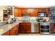 Cherry wood kitchen with granite countertops, stainless steel appliances, and ample cabinet space at 85 Carolwood Blvd, Fern Park, FL 32730
