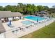 Community pool with lounge chairs, umbrellas, and a splash pool with mature trees in the background on a sunny day at 85 Carolwood Blvd, Fern Park, FL 32730