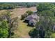 Aerial view of the home with a large lot surrounded by mature trees and expansive green space at 1 Huntley Ct, Haines City, FL 33844