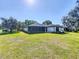 Spacious backyard with a well-maintained lawn, mature trees, and a screened lanai, perfect for outdoor enjoyment at 1 Huntley Ct, Haines City, FL 33844