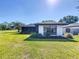 A well-manicured backyard with lush green grass and a screened-in porch perfect for outdoor relaxation at 1 Huntley Ct, Haines City, FL 33844