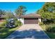 Charming single-story home with a manicured lawn, a two-car garage, and a golf cart parked in the driveway at 1 Huntley Ct, Haines City, FL 33844