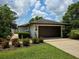Attached garage with meticulously landscaped lawn and garden creates a welcoming curb appeal at 1 Huntley Ct, Haines City, FL 33844