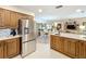 Open concept kitchen and dining area featuring an island with seating, stainless steel appliances and wood cabinets at 1 Huntley Ct, Haines City, FL 33844