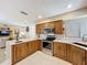 Bright kitchen featuring an island with white countertops, wooden cabinets, and stainless steel appliances at 1 Huntley Ct, Haines City, FL 33844