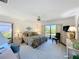 Bright main bedroom featuring large windows, ceiling fan, neutral carpet and furnishings, and exterior views at 1 Huntley Ct, Haines City, FL 33844