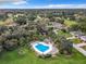 Aerial view of a community pool surrounded by lush landscaping and mature trees at 1 Huntley Ct, Haines City, FL 33844